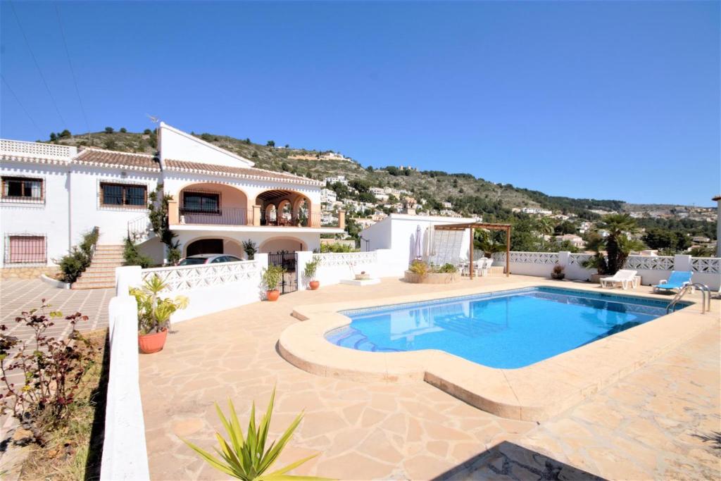 a villa with a swimming pool and a house at Holiday Home Calas in Jávea