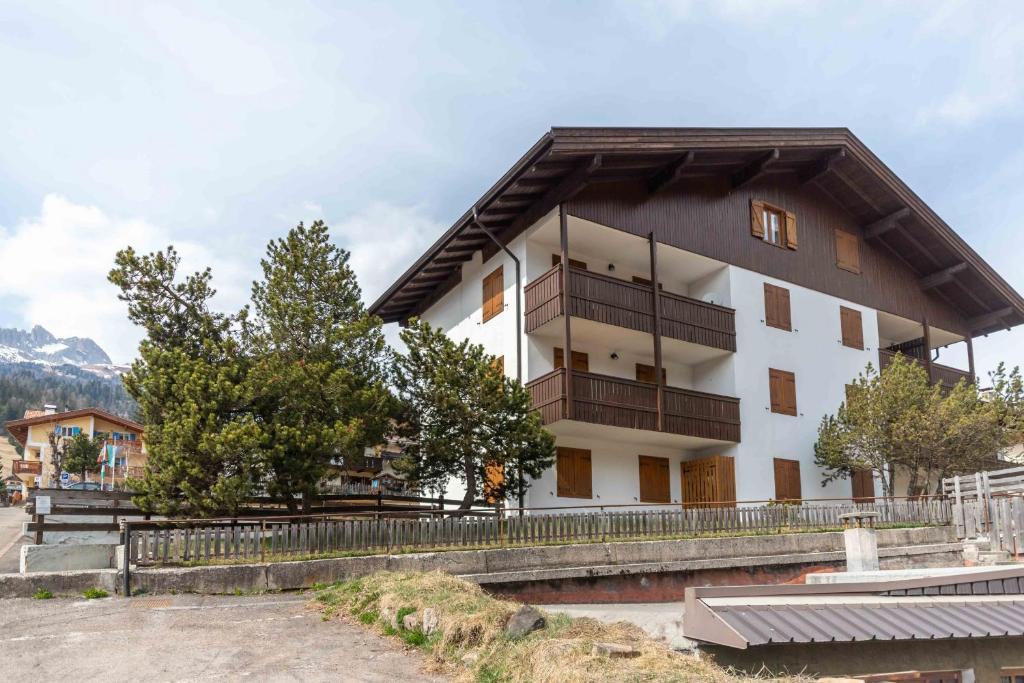 a white building with a wooden roof at Chalet Catinaccio in Soraga