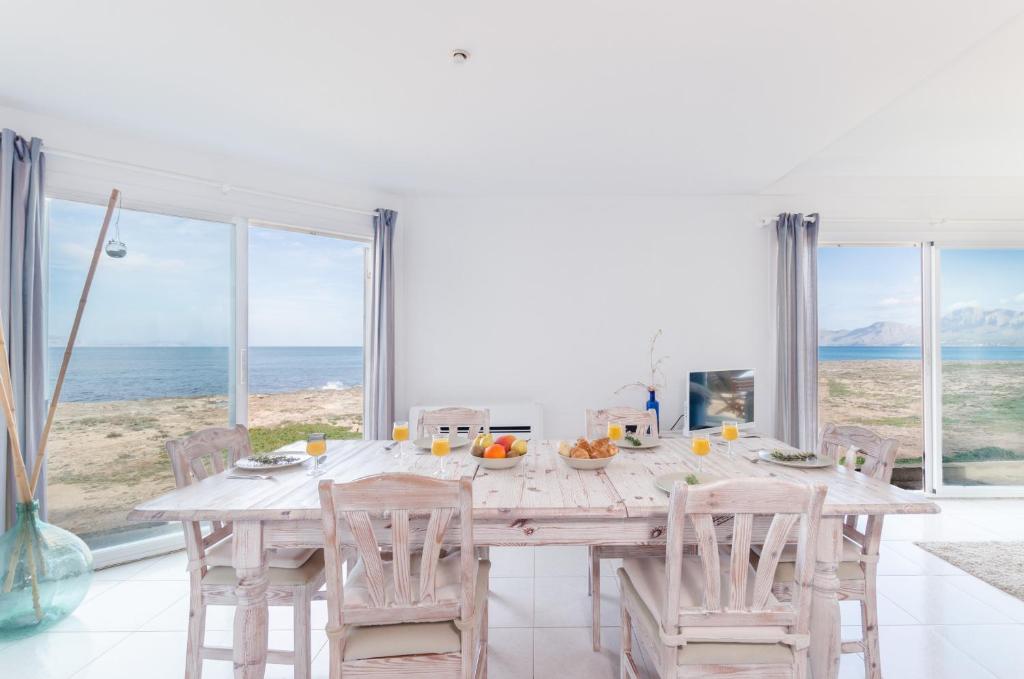 una sala da pranzo con tavolo e vista sull'oceano di YourHouse Solmarina Son Serra a Son Serra de Marina