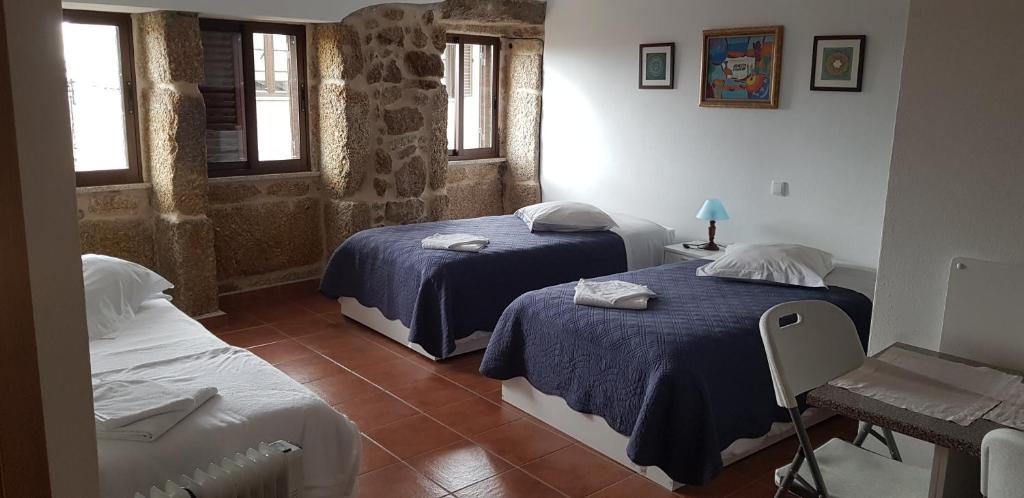 um quarto com duas camas e uma mesa e uma cama em Casa Dom Yahya em Belmonte