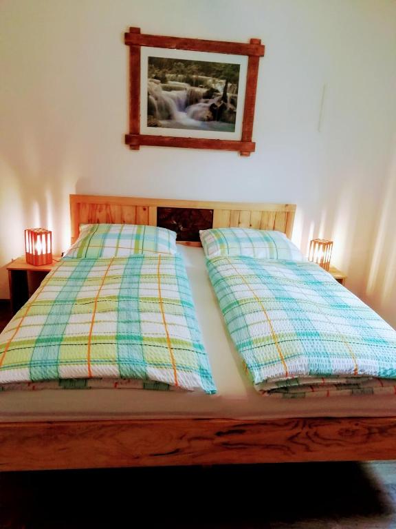 a bed with two pillows and a picture on the wall at Ferienwohnung Familie Faath in Bellheim