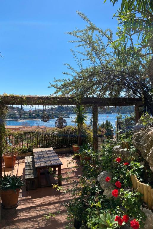 - un jardin avec une table de pique-nique et des fleurs dans l'établissement La Barmassa, à Villefranche-sur-Mer