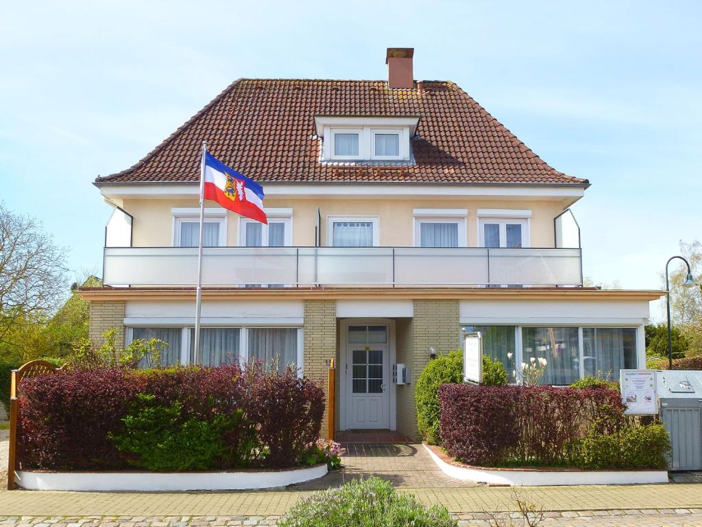 a house with a flag in front of it at Ferienwohnungen & Bungalows Waldstraße 15 Kellenhusen in Kellenhusen
