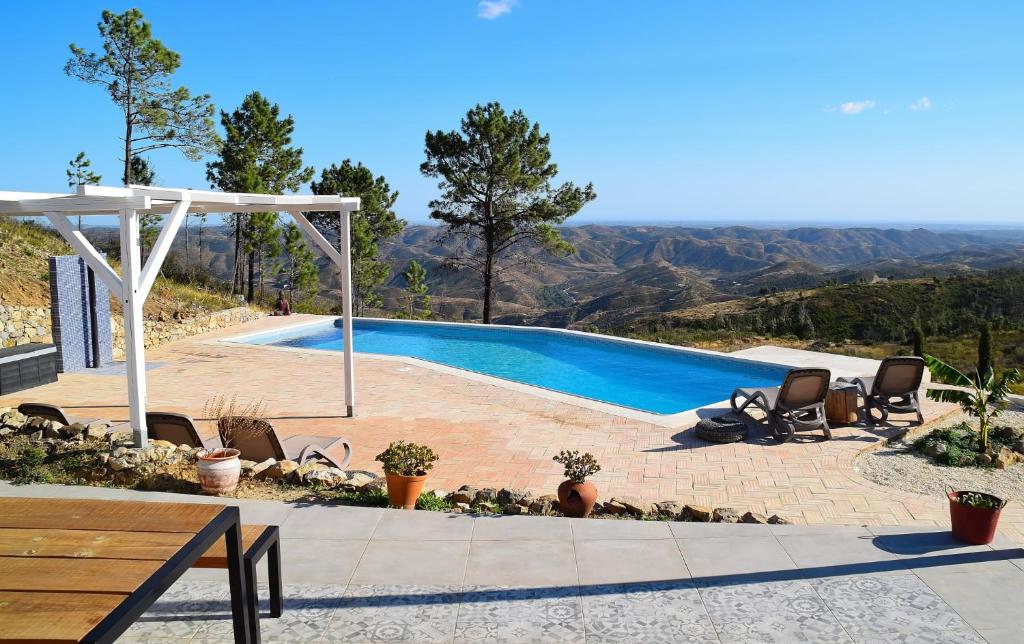 a swimming pool with a view of the mountains at Quinta O Ninho in Monchique