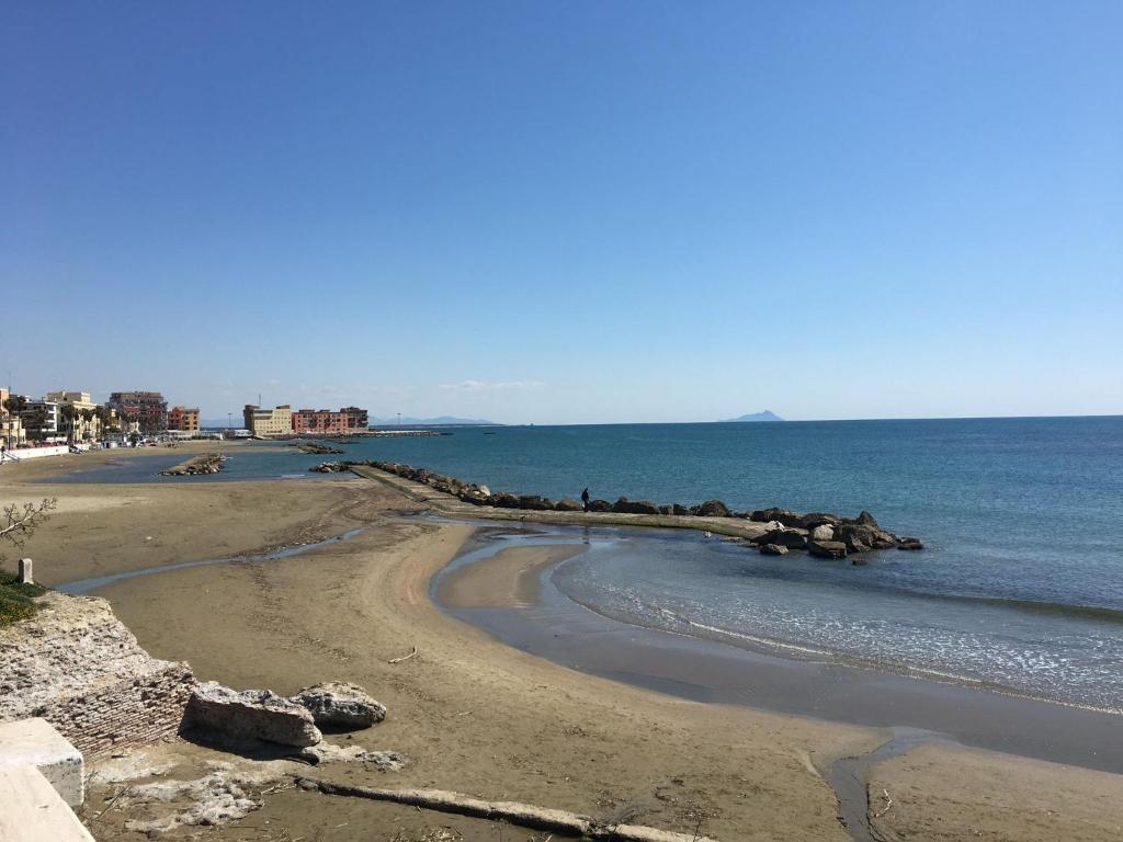 una playa con rocas y el océano en un día soleado en Alloggio Turistico Dea Bendata, en Anzio