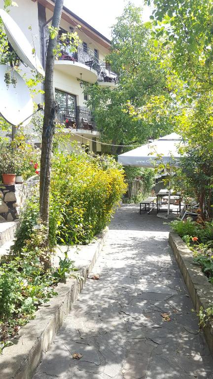 a sidewalk with tables and umbrellas next to a building at pensiunea top demac in Slănic