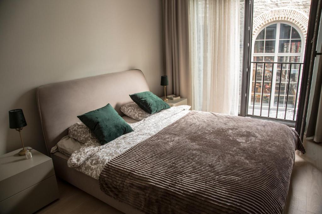 - une chambre avec un lit doté d'oreillers verts et d'une fenêtre dans l'établissement Dream Stay - Executive Apartment with Balcony, à Tallinn