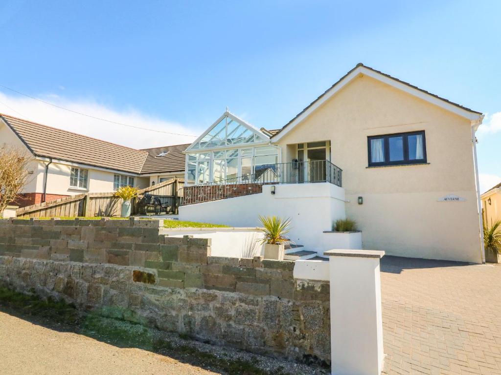 a house with a glass facade and stairs at Auverne in Bude