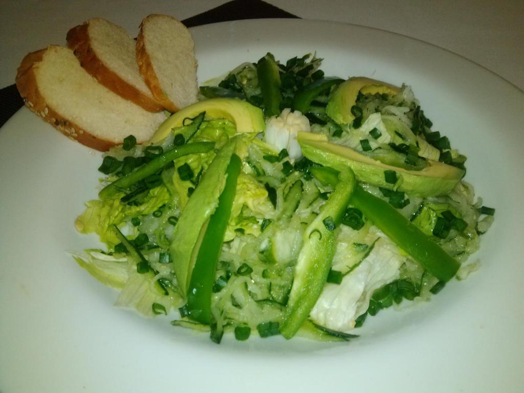 a white plate of food with greens and vegetables at Hotel Aeropuerto Los Cabos in San José del Cabo