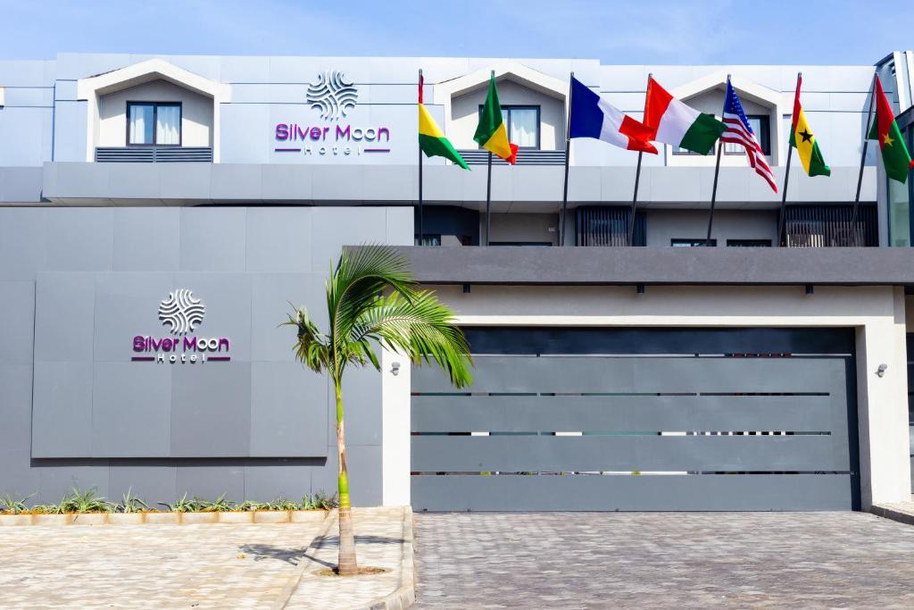 a building with many different flags on top of it at Silver Moon Hotel in Abidjan