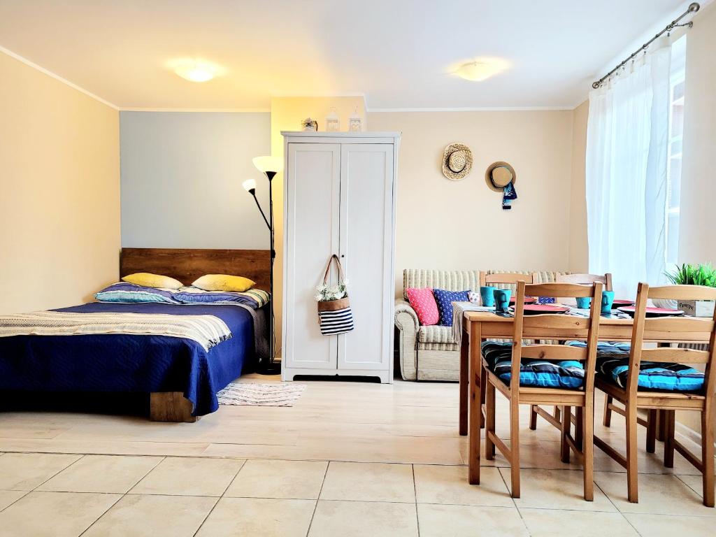 ウストカにあるApartamenty Blisko Morzaのベッドルーム1室(ベッド1台、テーブル、椅子付)