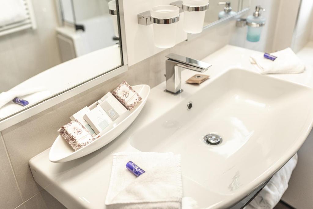 a bathroom with a white sink and a mirror at Boutique Hotel Albana Real - Restaurants & Spa in Zermatt