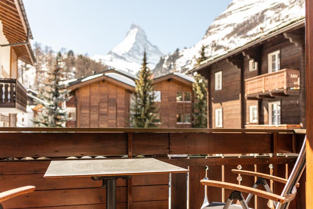 a table and two chairs on a balcony with a mountain at Boutique Hotel Albana Real - Restaurants & Spa in Zermatt