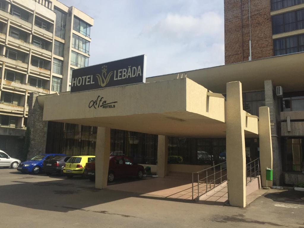 a hotel lobby with cars parked in a parking lot at Hotel Lebăda in Amara