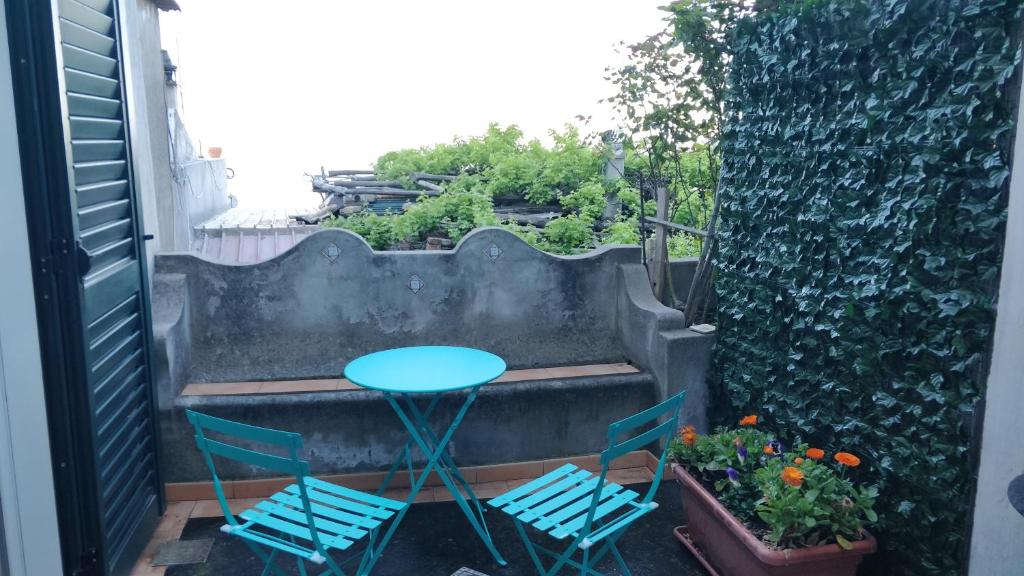 une terrasse avec 2 chaises, une table et des plantes dans l'établissement Appartamenti Magnolia, à Positano