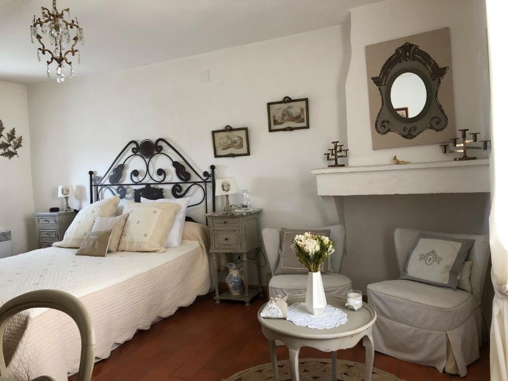 une chambre avec un lit, une chaise et un miroir dans l'établissement Maison de village en Provence, à Baudinard