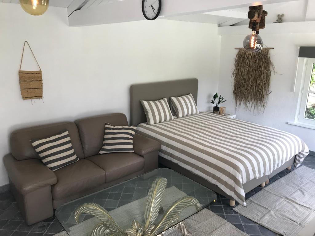 ein Wohnzimmer mit einem Sofa und einem Bett in der Unterkunft Aquavilla Bed & Breakfast in Willebroek