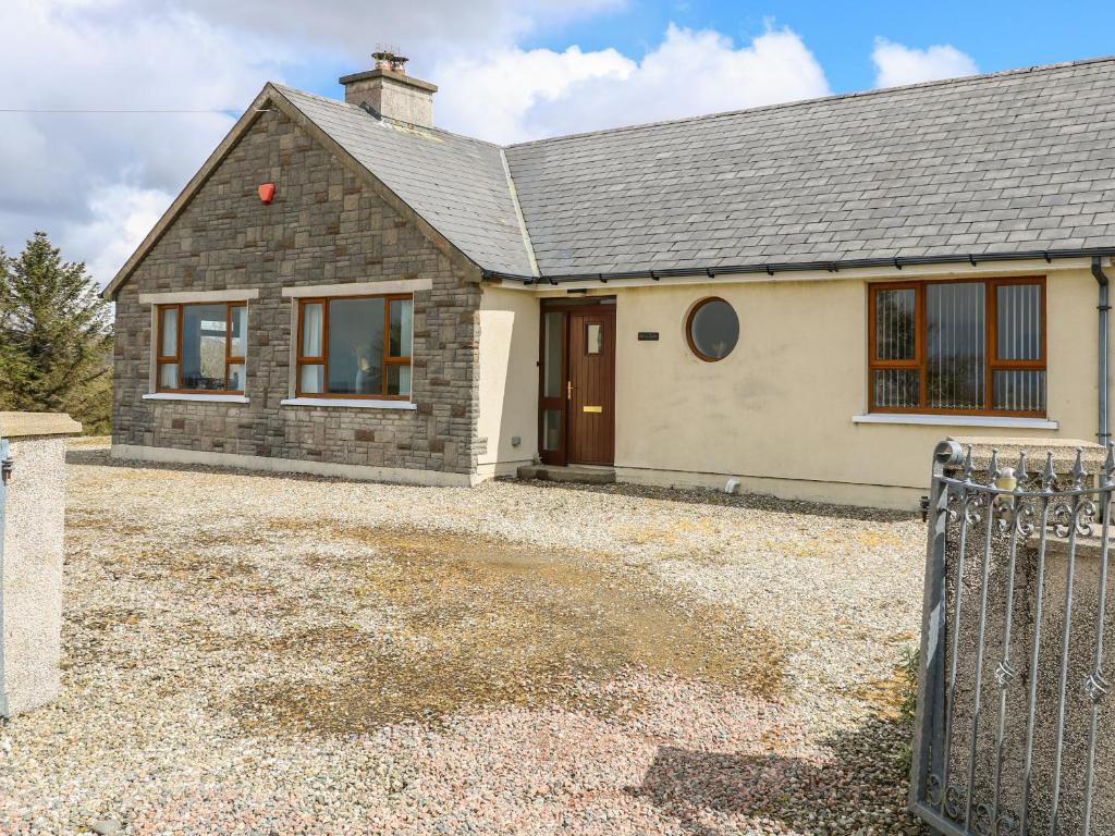a house with a gravel driveway in front of it at Ard na Gréine in Kilrean