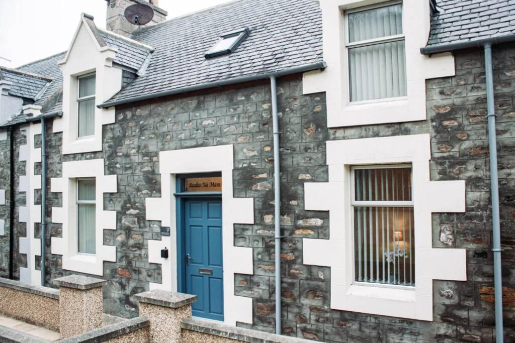 a house with a blue door and white windows at Craigewan Cottage Seatown Cullen in Cullen