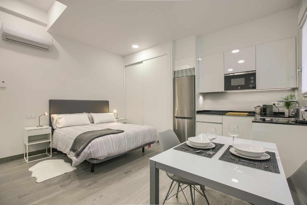 a bedroom with a bed and a table and a kitchen at RiNa MADRID apartamento 2 in Madrid