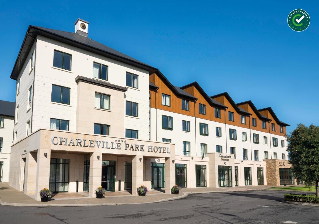 Charleville Park Hotel & Leisure Club IRELAND في شارفيل: مبنى أبيض كبير مع فندق حديقة