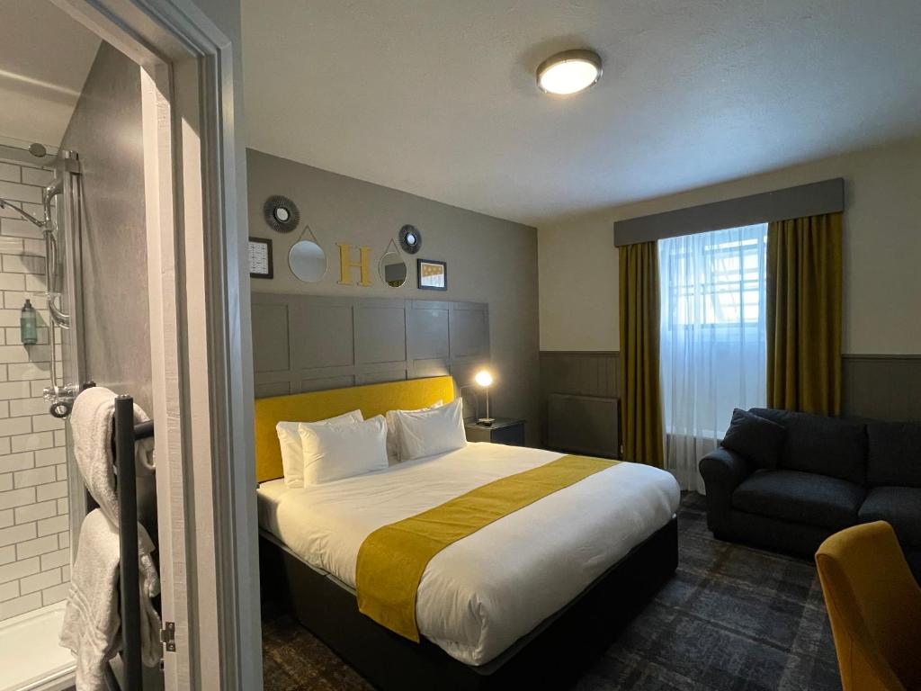 ハバーフォードウェストにあるThe County Hotelのベッドとソファ付きのホテルルーム