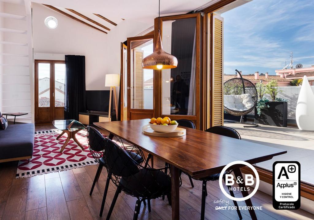 comedor con mesa de madera y sillas en B&B Apartamentos Madrid Centro Fuencarral 46, en Madrid