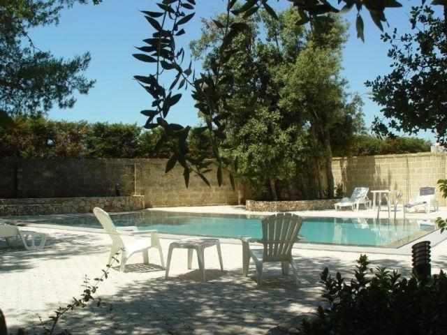 - une piscine avec 2 chaises, une table et des chaises dans l'établissement Residence la Vallona, à Spongano