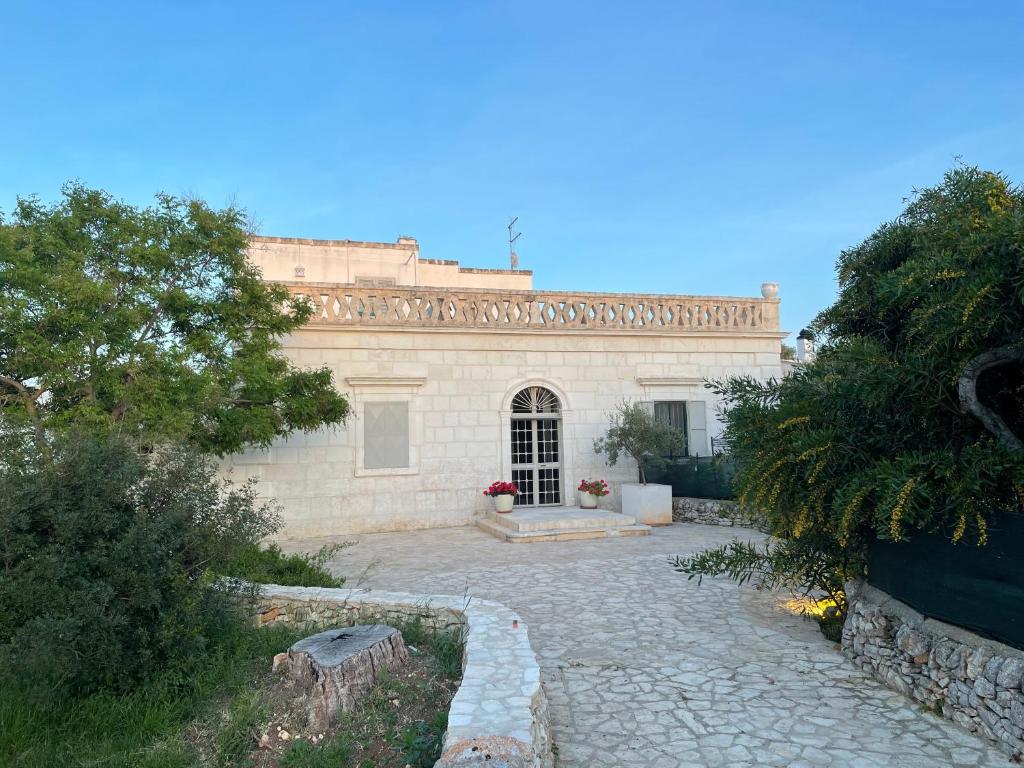 a house with a stone driveway in front of it at Masseria della Piana in Villanova di Ostuni