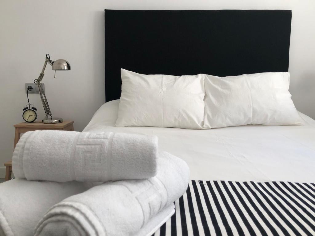 a white bed with a black headboard and white pillows at Apartamento Algazul in Las Negras