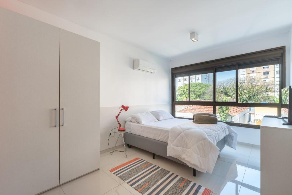 a bedroom with a bed and a large window at Apartamento Rua Casemiro de Abreu, 199 in Porto Alegre