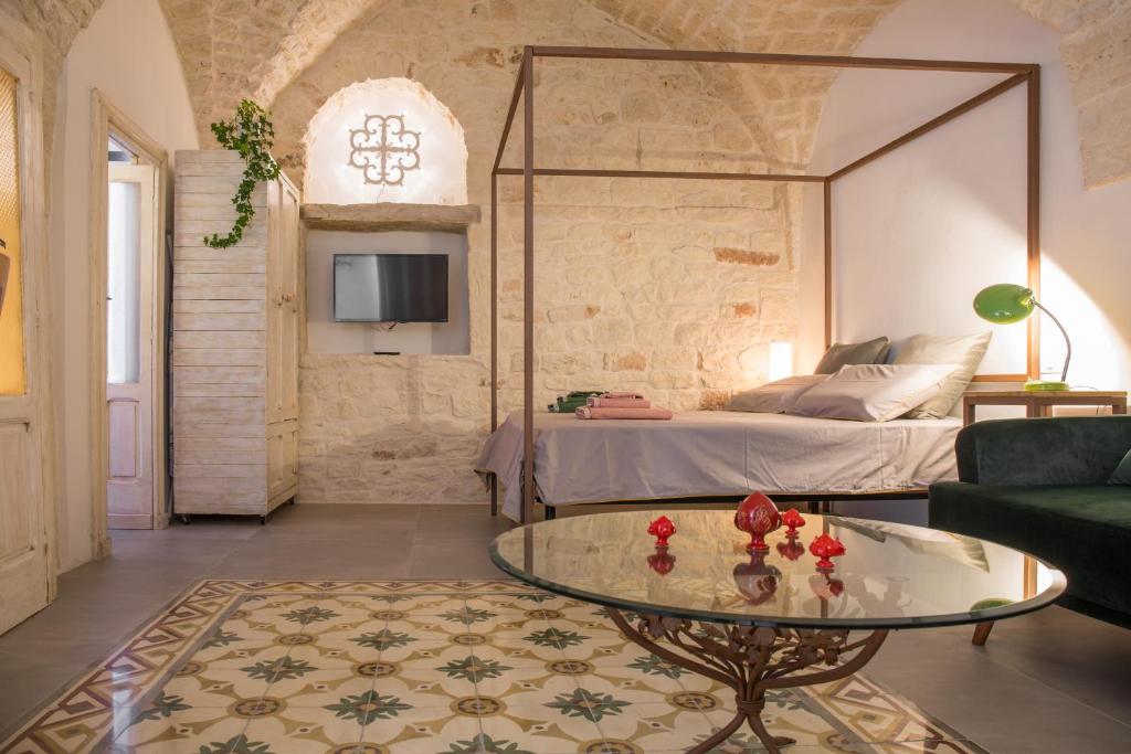 Sala de estar con cama y mesa de centro de cristal en La Casa di Agata, en Ceglie Messapica