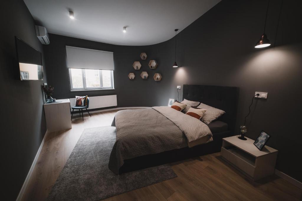 a black bedroom with a bed and a rug at Apart-hotel Kostjukowski Apartments Nizhynska 17 in Lviv