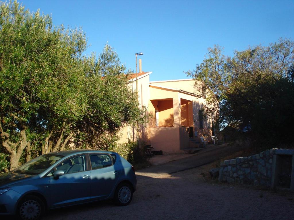 mały niebieski samochód zaparkowany przed domem w obiekcie Casa Vacanza Costa Rossa vista mare w mieście Trinità dʼAgultu