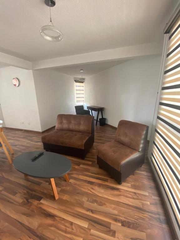 ein Wohnzimmer mit einem Sofa und einem Tisch in der Unterkunft Bonito departamento frente a metro cuatro caminos in Mexiko-Stadt
