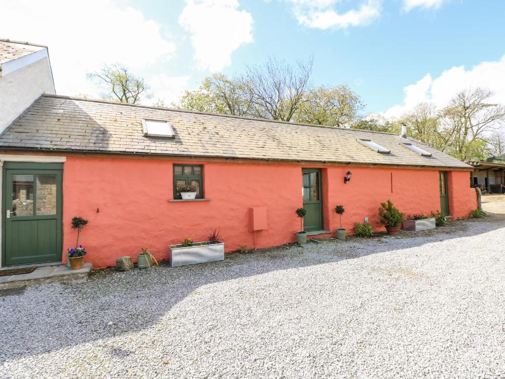 a red house with plants on the side of it at Blueberry Cottage in Haverfordwest