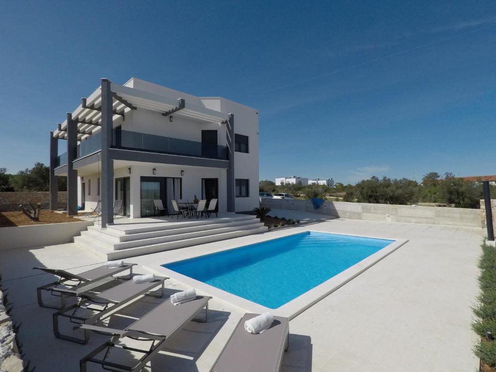 a villa with a swimming pool in front of a house at Villa Neva in Vodice