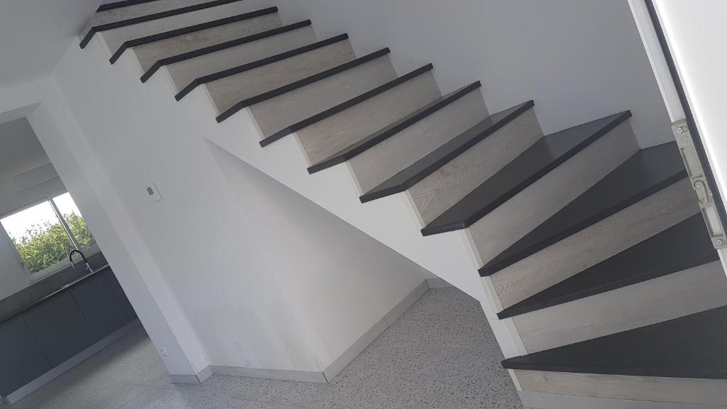 a staircase in a house with wood treads at Villa 2 luxe in Fresney-le-Vieux