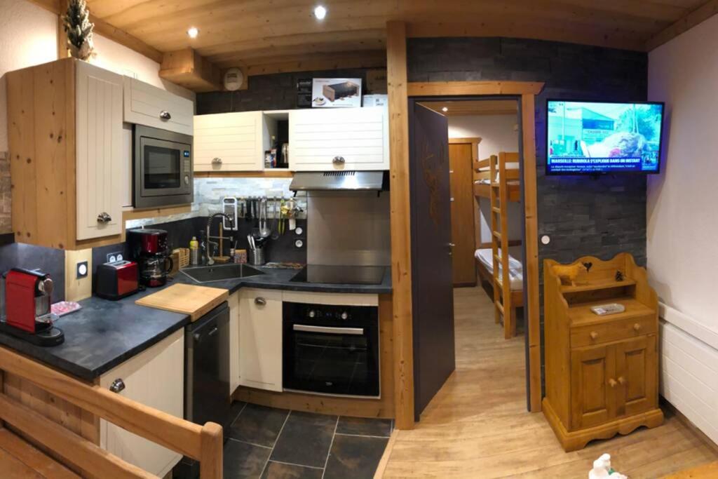 eine Küche mit einer Spüle und einem Herd Top-Backofen in der Unterkunft Studio TMB - Le Praz de Lys in Le Praz de Lys