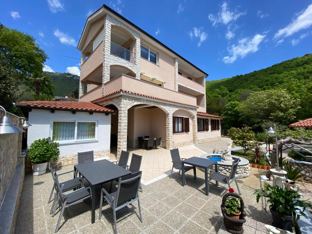 Casa con patio con mesa y sillas en Guest House Dešković, en Mošćenička Draga