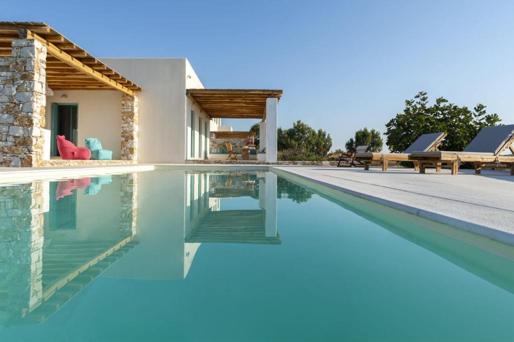 a swimming pool with a villa in the background at Pandesia Villas Private Pools in Mármara