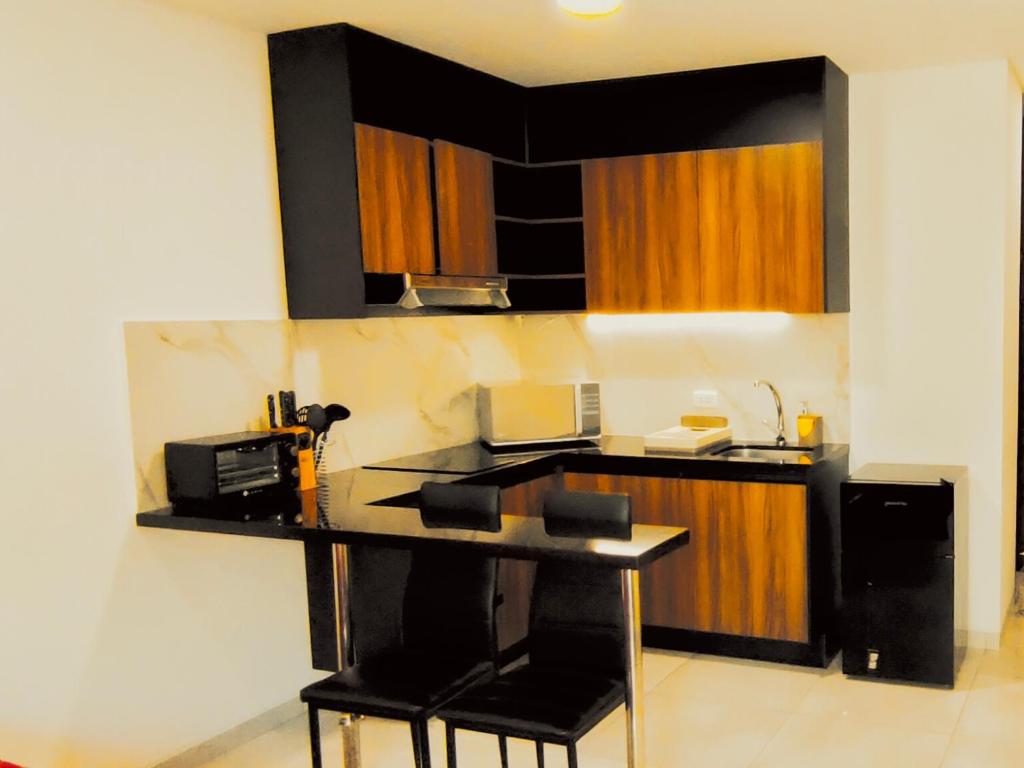 a kitchen with a counter with a table and chairs at Private Garzonier Las Palmas in Santa Cruz de la Sierra