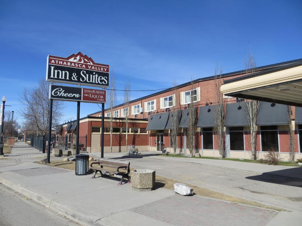 una señal para una posada y suites en una calle de la ciudad en Athabasca Valley Inn & Suites, en Hinton