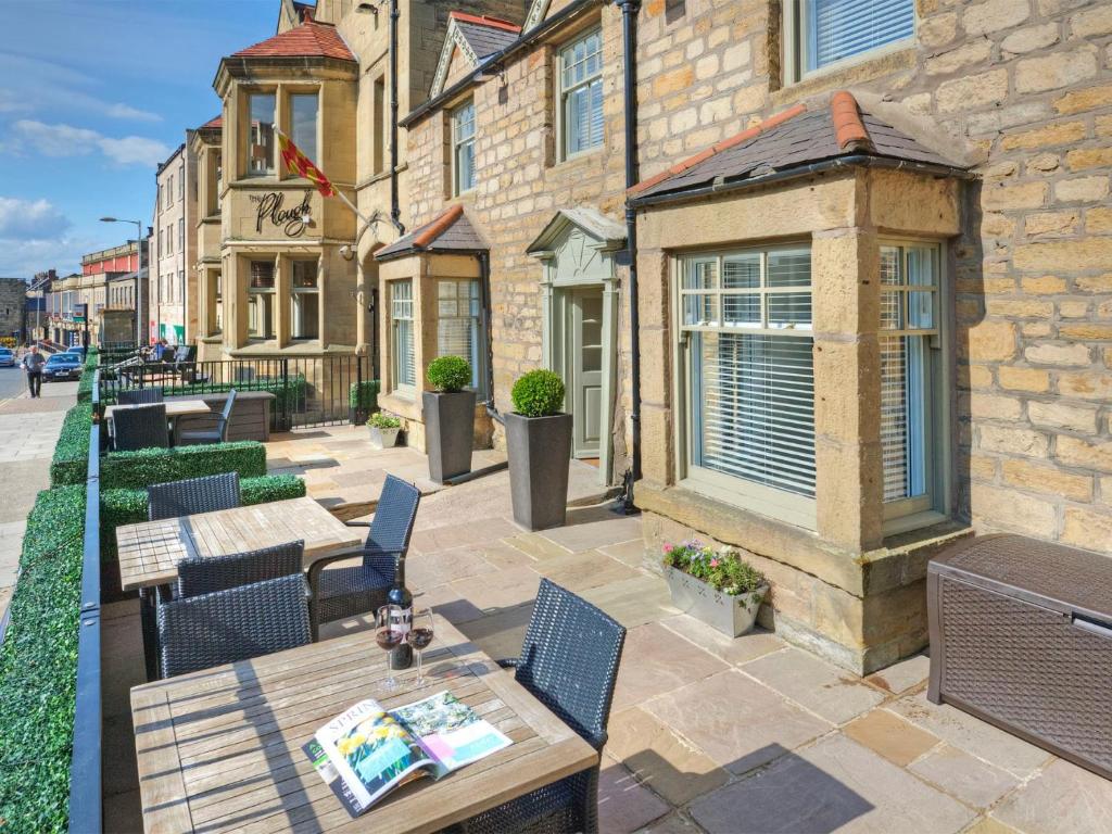 a patio with tables and chairs and a building at The Bondgate Boutique in Alnwick