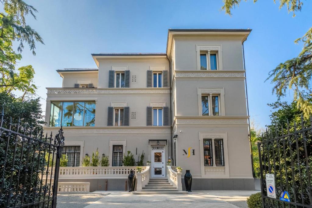a large white house with stairs in front of it at Mysuiteshome Apartments in Bologna