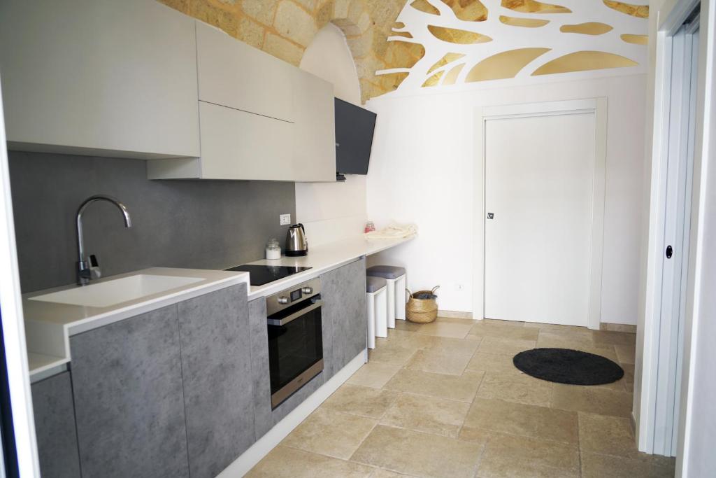una cucina con armadi bianchi e lavandino di 36 Metri quadri a Polignano a Mare