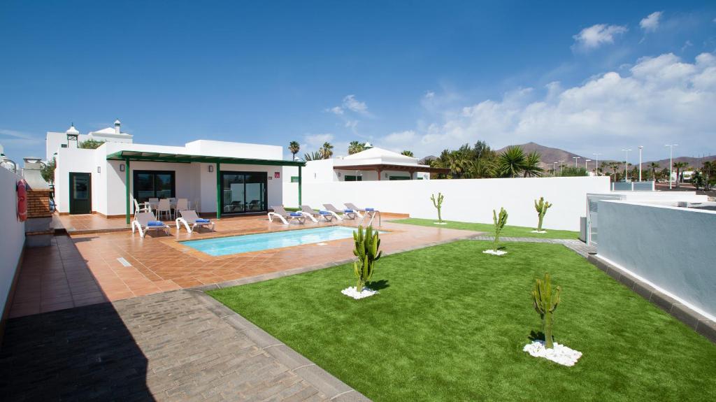 a backyard with a swimming pool and a house at Blancazul Brisa Marina in Yaiza
