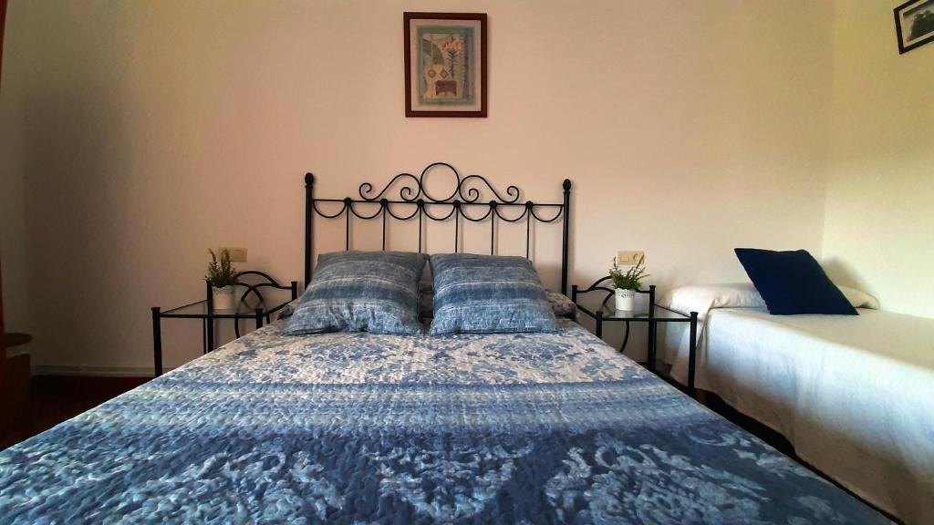a bedroom with a bed with a blue comforter at CASA LA REVERENDA in Barcia
