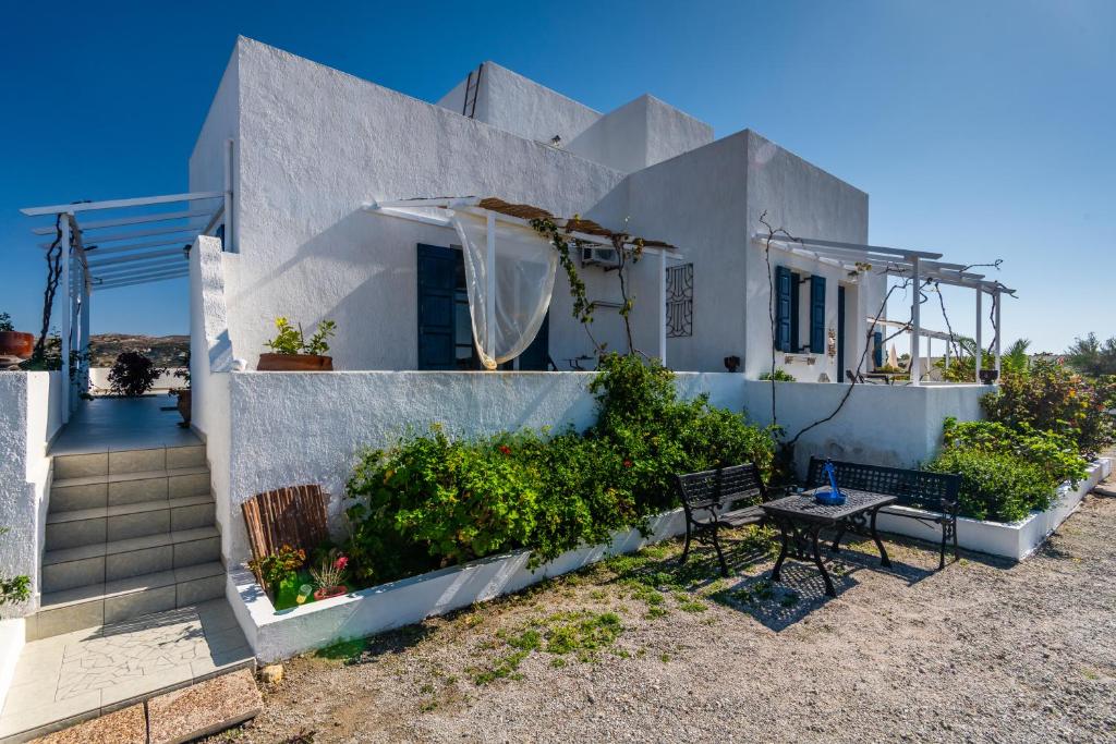 a white house with a table and chairs in front of it at Tzivaeri Studios in Zefiría