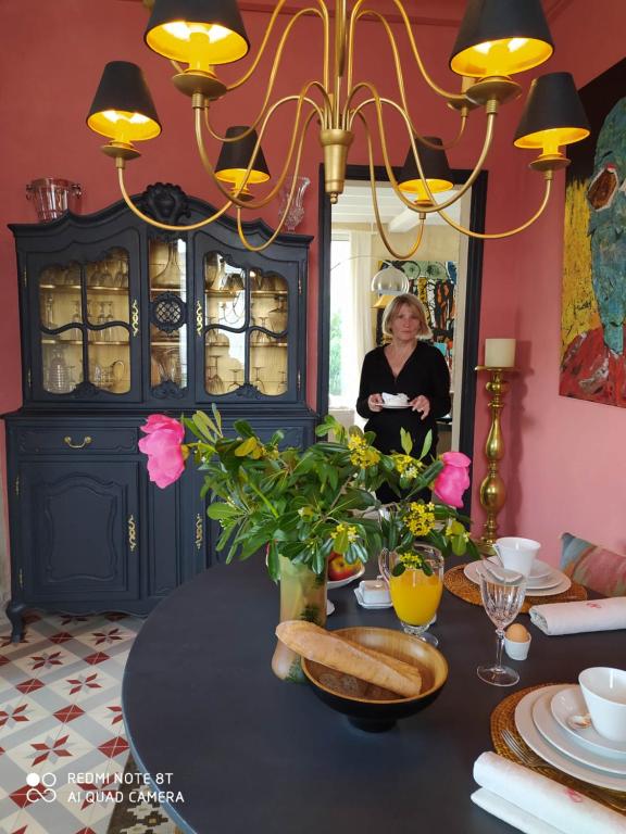 uma mulher sentada numa mesa numa sala de jantar em Suite dans Une Echoppe em Bègles